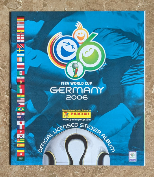 FIFA World Cup Germany 2006 sticker album cover with soccer player and flags.